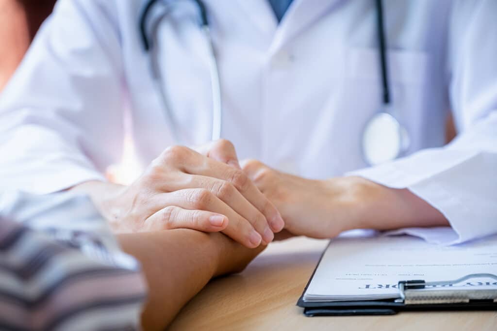 The doctor hands holding patient hand to encouragement